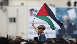طفل فلسطيني يرفع علم بلاده