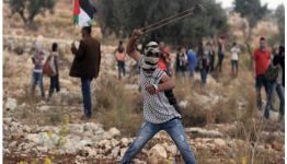 طفل فلسطيني يرمي حجر بمقلاع