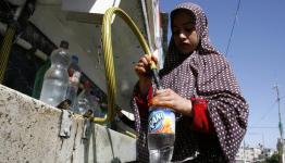 لاجئة فلسطينية تملئ مياه الشرب داخل القوارير