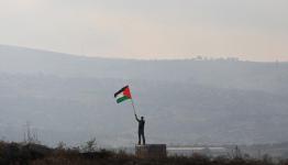 شاب يرفع العلم الفلسطيني