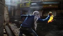 فلسطيني يلقي زجاجة حارقة 