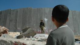 طفل فلسطيني اعزل يقابله جندي مدجج بالسلاح