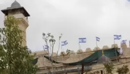 أعلام الاحتلال تدنس جدران المسجد الإبراهيمي