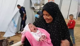 ام  فلسطينية مع  طفلتها الرضيعة