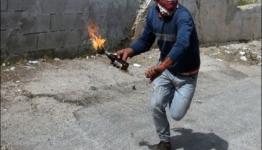 فلسطيني يرمي زجاجة حارقة