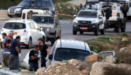 جنود العدو يحيطون بسيارة مستوطن استهدفها فلسطيني قرب الخليل 