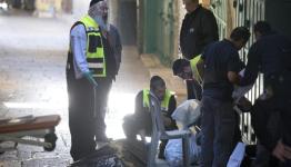 أعضاء فريق أمني إسرائيلي ينقلون جثة شهيد فلسطيني قُتل بعد طعنه شرطيا بالقدس القديمة 