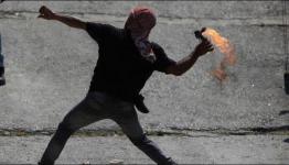 شاب فلسطيني يلقي المولوتوف على العدو