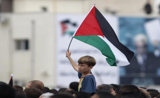 طفل فلسطيني يرفع علم بلاده