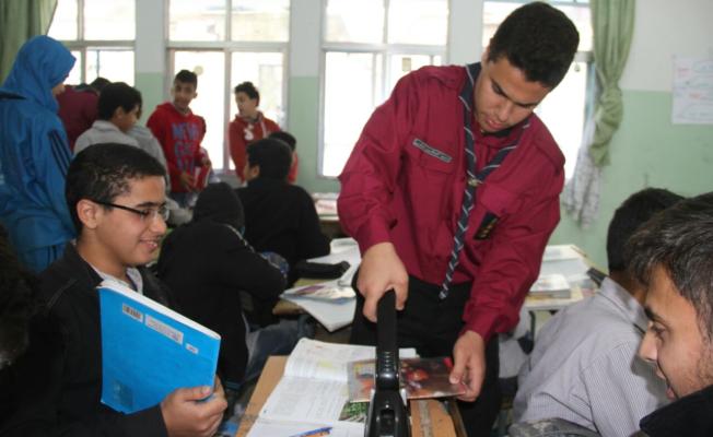 أحد الكشفيين يقوم بتكبيس كتاباًُ