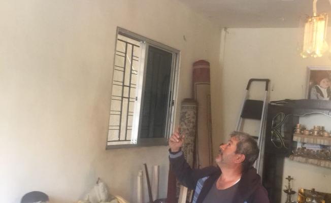 غنام يشير إلى سقف منزله المتصدع