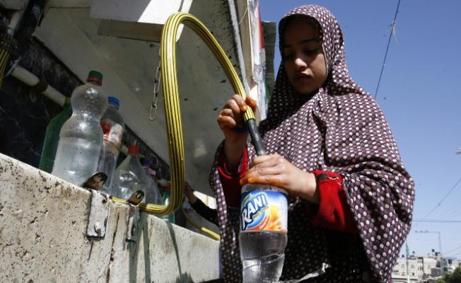 لاجئة فلسطينية تملئ مياه الشرب داخل القوارير
