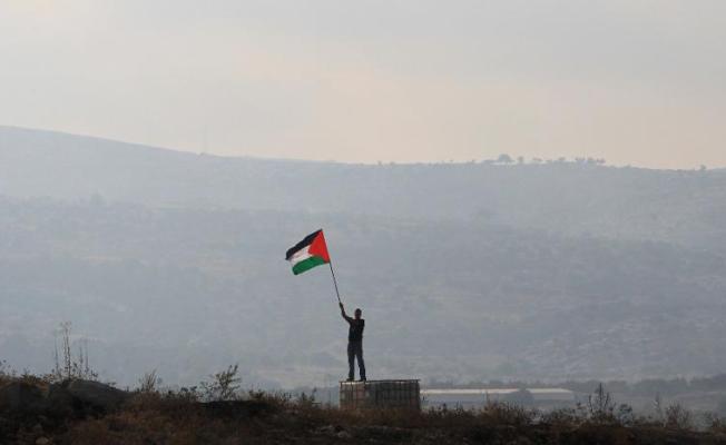 شاب يرفع العلم الفلسطيني