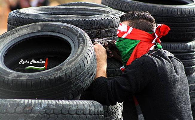 شاب فلسطيني يحتمي بالاطارات