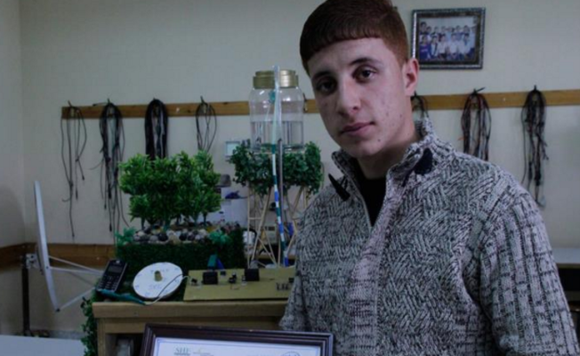 مفيد علاونة بجانب مشروعه الذي فاز بالمركز الثاني في مجال الهندسة البيئية ضمن مسابقة إنتل للعلوم-العالم العربي