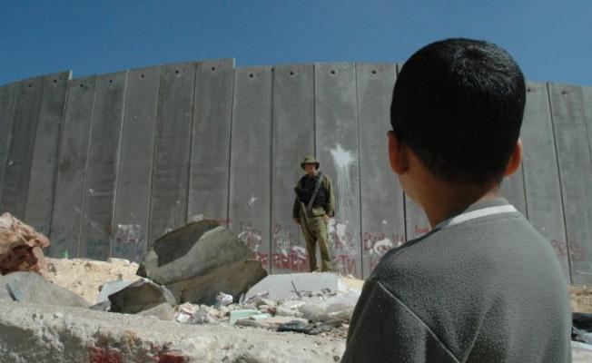 طفل فلسطيني اعزل يقابله جندي مدجج بالسلاح