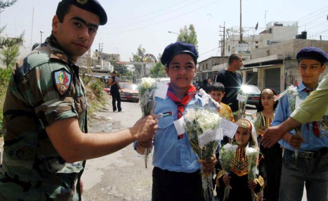  أطفال عين الحلوة يقدمون الورود لعسكري في الجش اللبناني