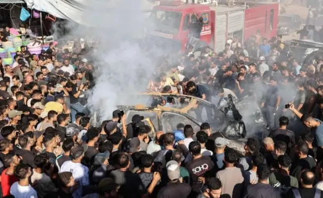 غزيون يتابعون نتائج غاترة اسرائيلية استهدفت مركبة