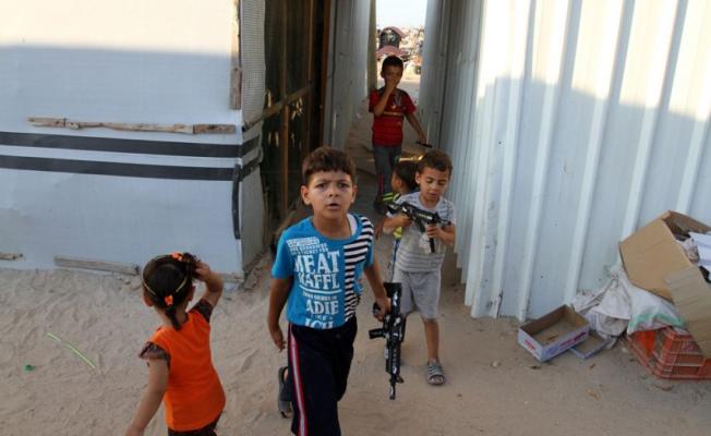أطفال يحملون أسلحة بلاستيكية