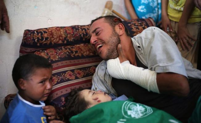 والد الطفلة الشهيدة رهف أثناء وداعها