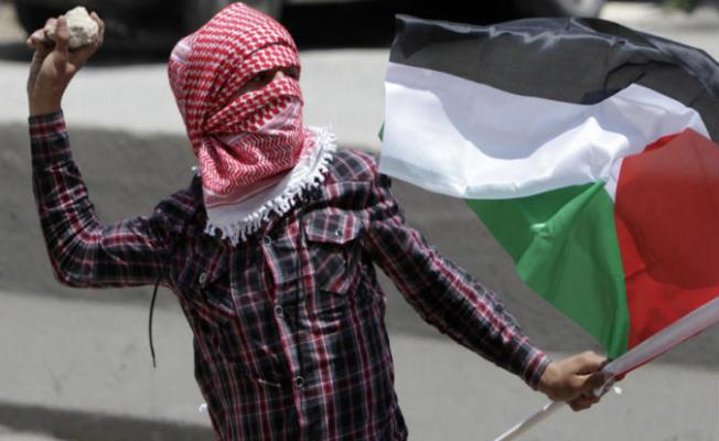 فلسطيني يرشق الحجارة