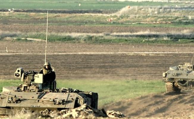 جنود خلف آلياتهم العسكرية المتقدمة بالقرب من السياج الحدودي