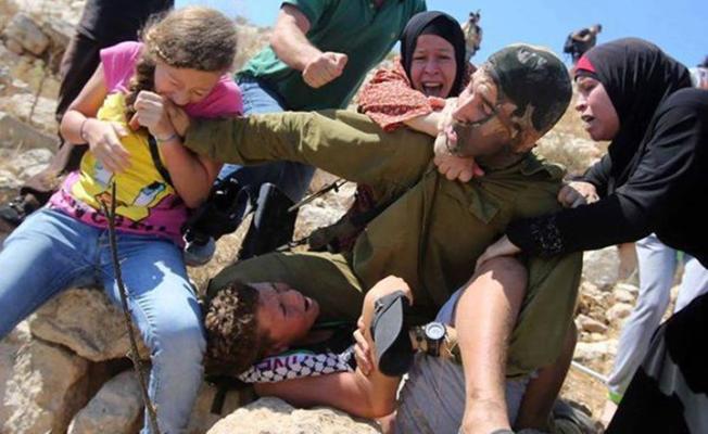جندي إسرائيلي يحاول اعتقال طفل فلسطيني