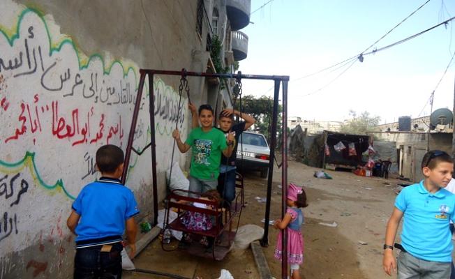 أطفال يلعبون على المراجيح بغزة